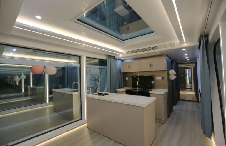 Spacious interior of LUBAN CABIN K70 featuring a modern kitchen with an island, large windows, and LED lighting.