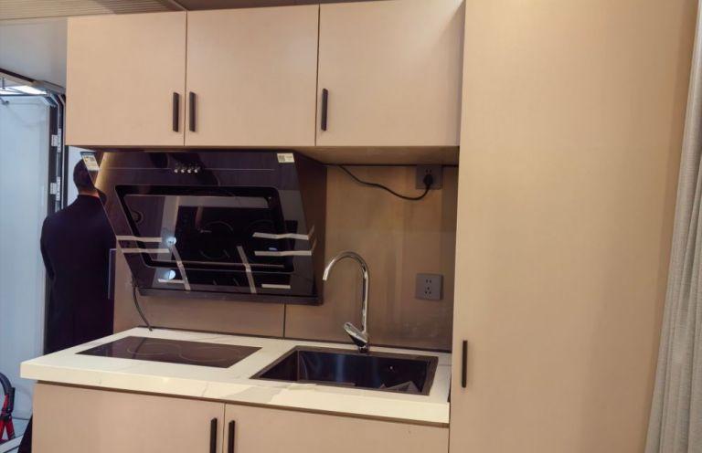 Kitchenette in LUBAN CABIN K70 featuring beige cabinets, a built-in wine rack, and modern sink.